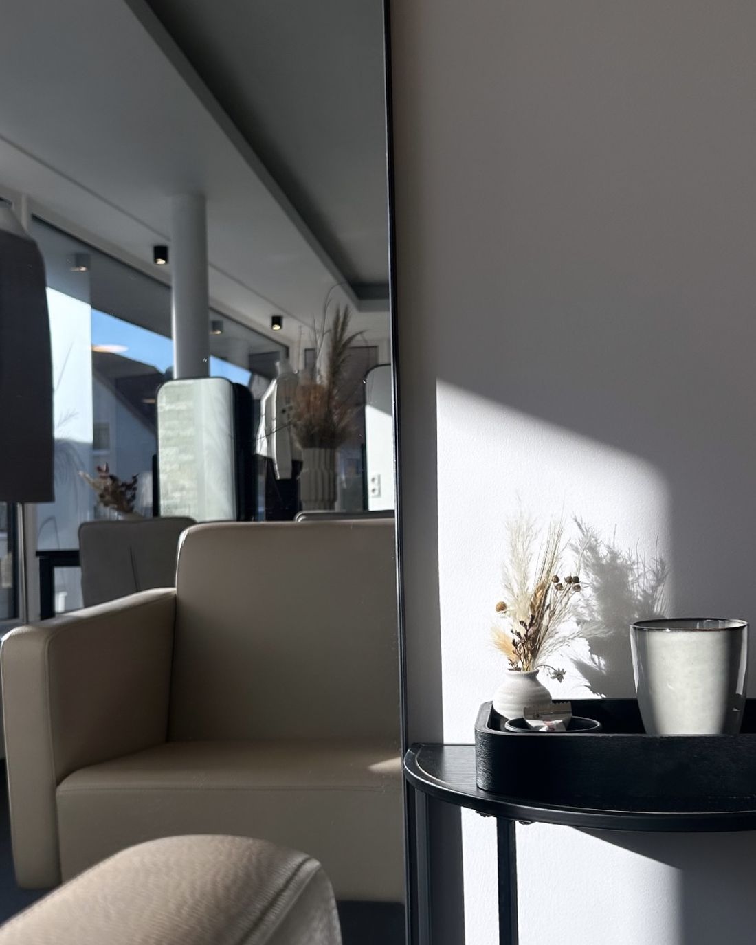 Ruhige Ecke im Salon mit Trockenblumen im Sonnenlicht